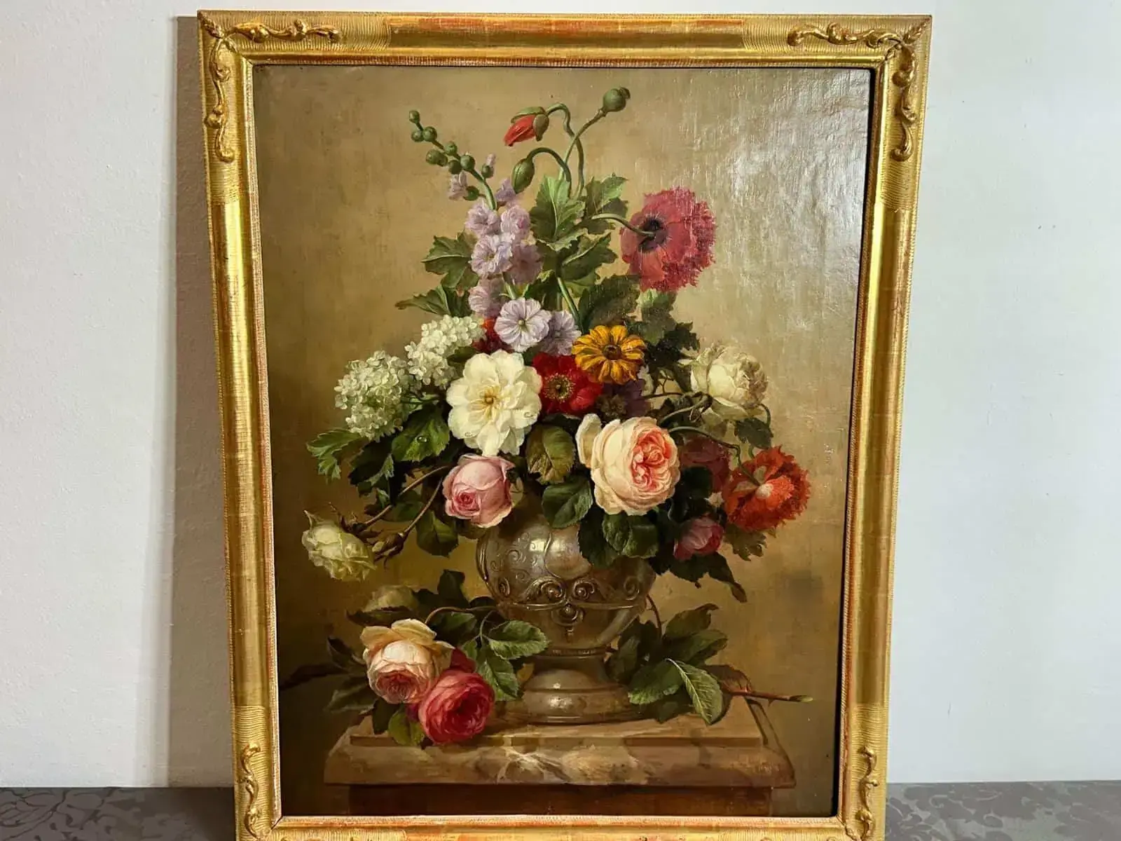 Un tableau encadré représentant une composition florale dans un vase décoratif, que j'ai craqué pour l'acheter. Le bouquet est composé de roses, de pivoines et de diverses autres fleurs dans des tons de rose, de blanc et de rouge. Il est présenté sur un fond neutre, mettant en valeur les couleurs vives.