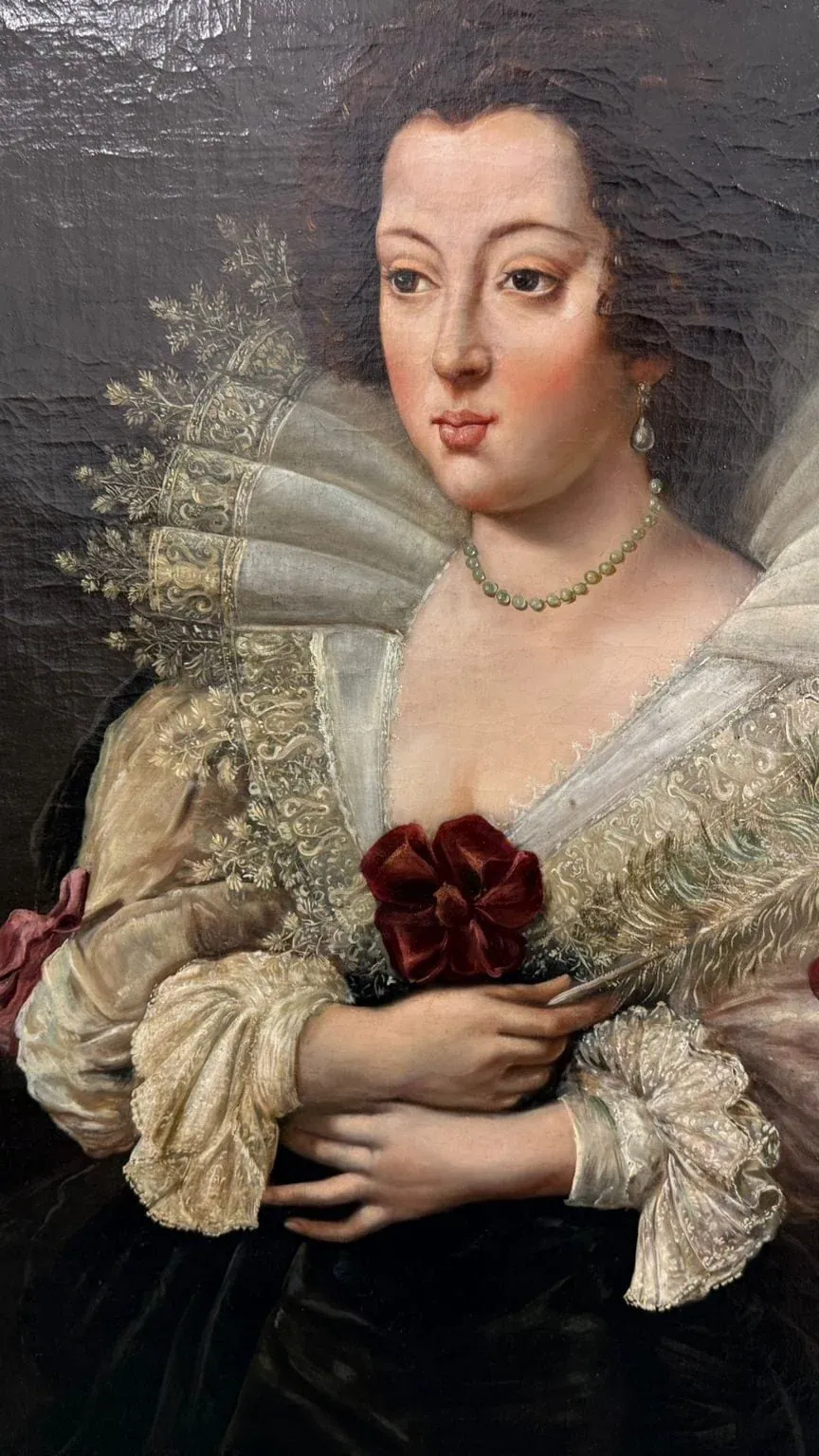 Peinture à l'huile classique représentant une femme à la peau pâle et aux cheveux bruns, portant une robe à col à volants élaborée avec de la dentelle, un collier de perles et tenant un éventail à plumes et des fleurs rouges, sur un fond sombre d'inspiration neuchâteloise.