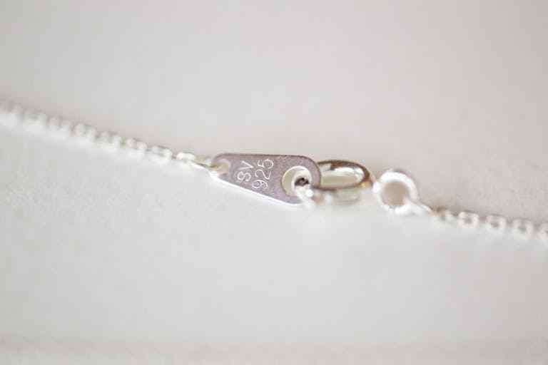 Detailed view of a sterling silver clasp on a necklace chain.