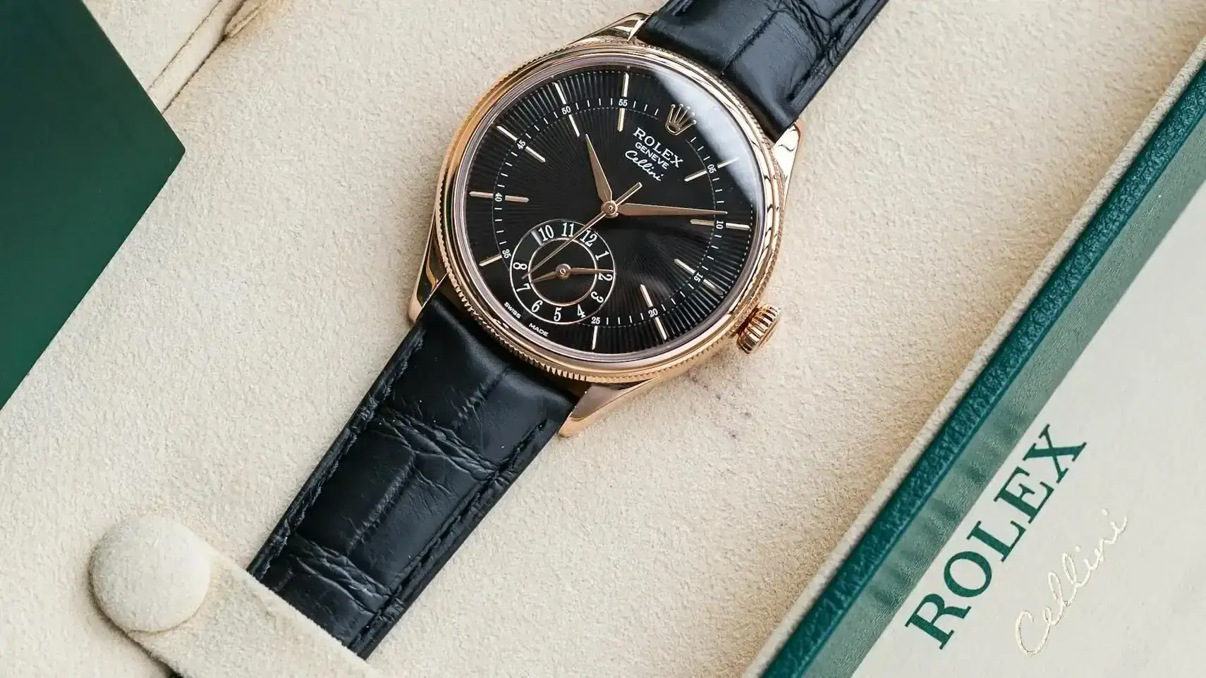 Elegant Rolex watch displayed in a luxury box with green accents and leather strap.