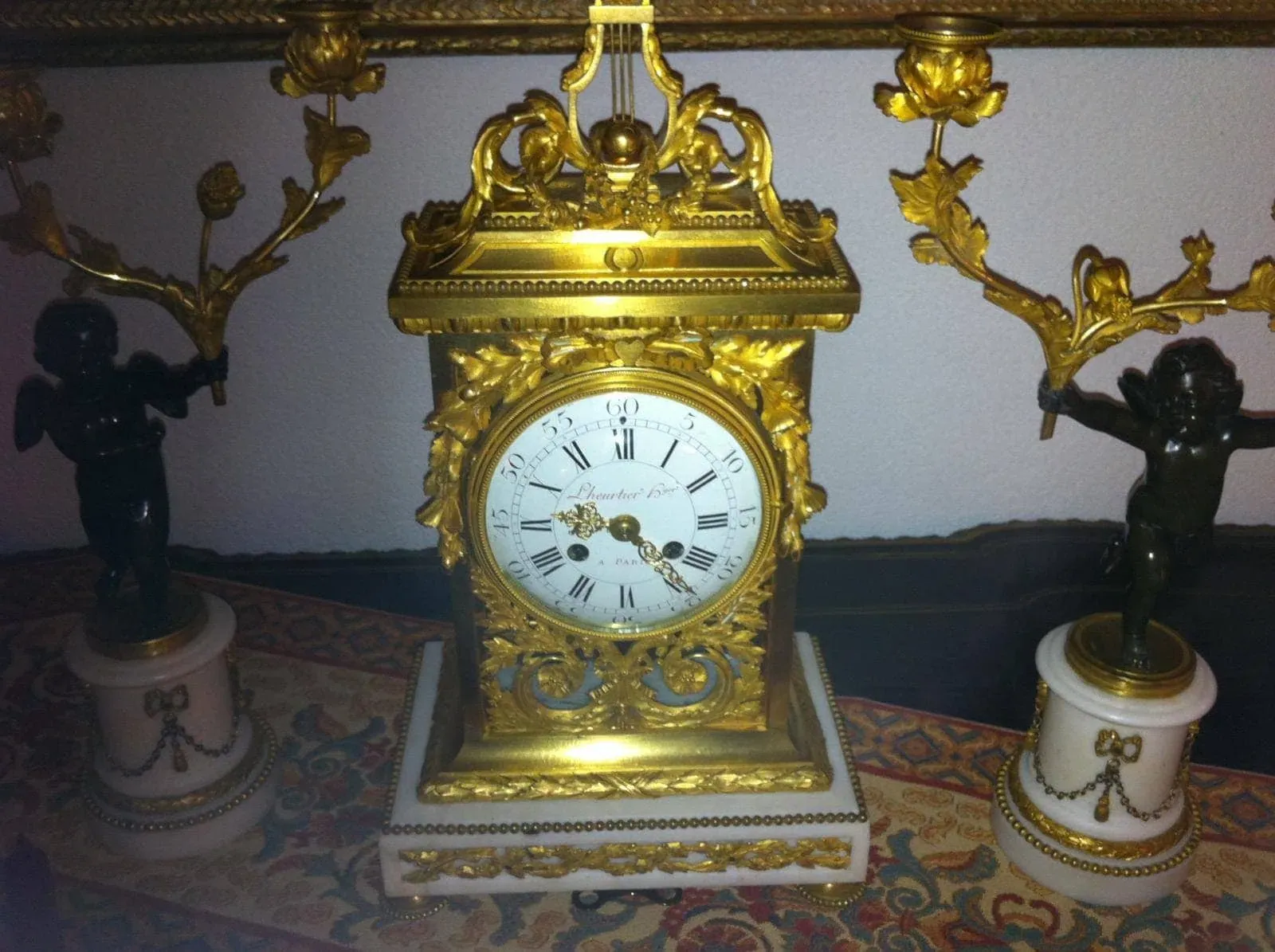 Horloge dorée avec deux statuettes ailées.