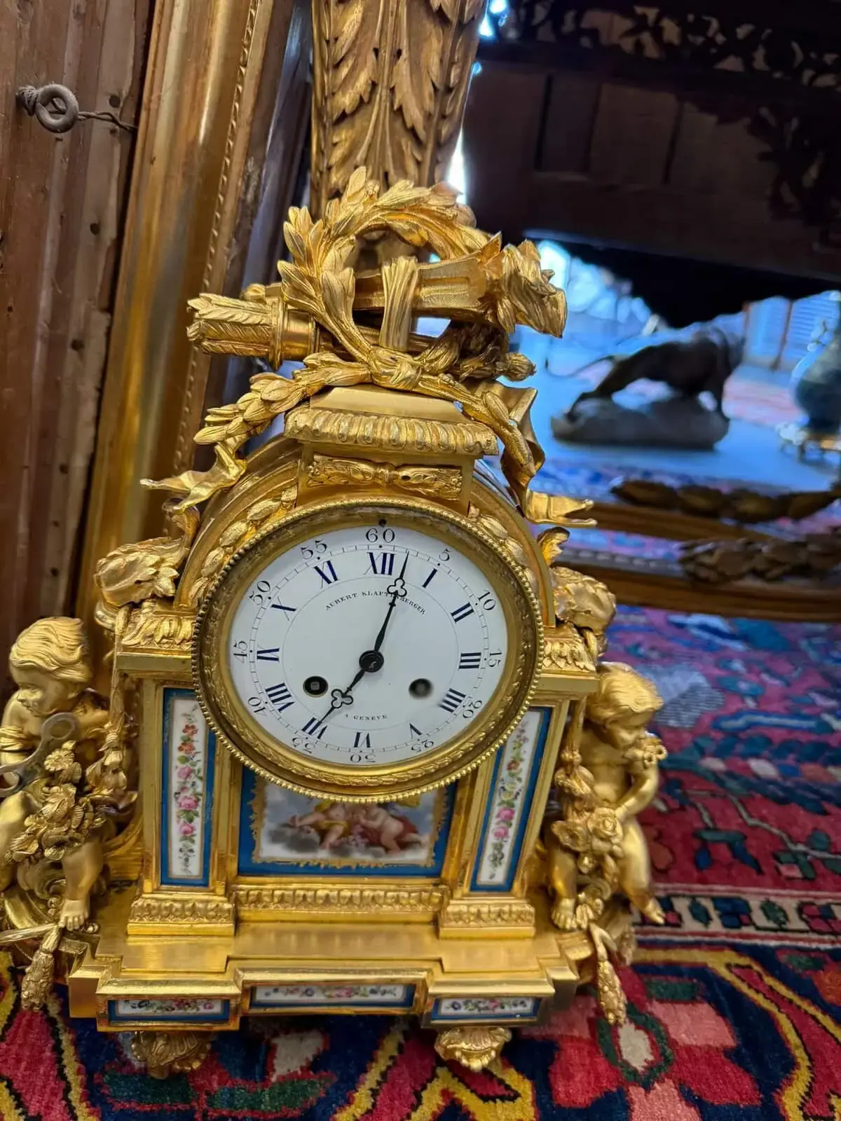 Horloge baroque dorée avec anges en décoration.