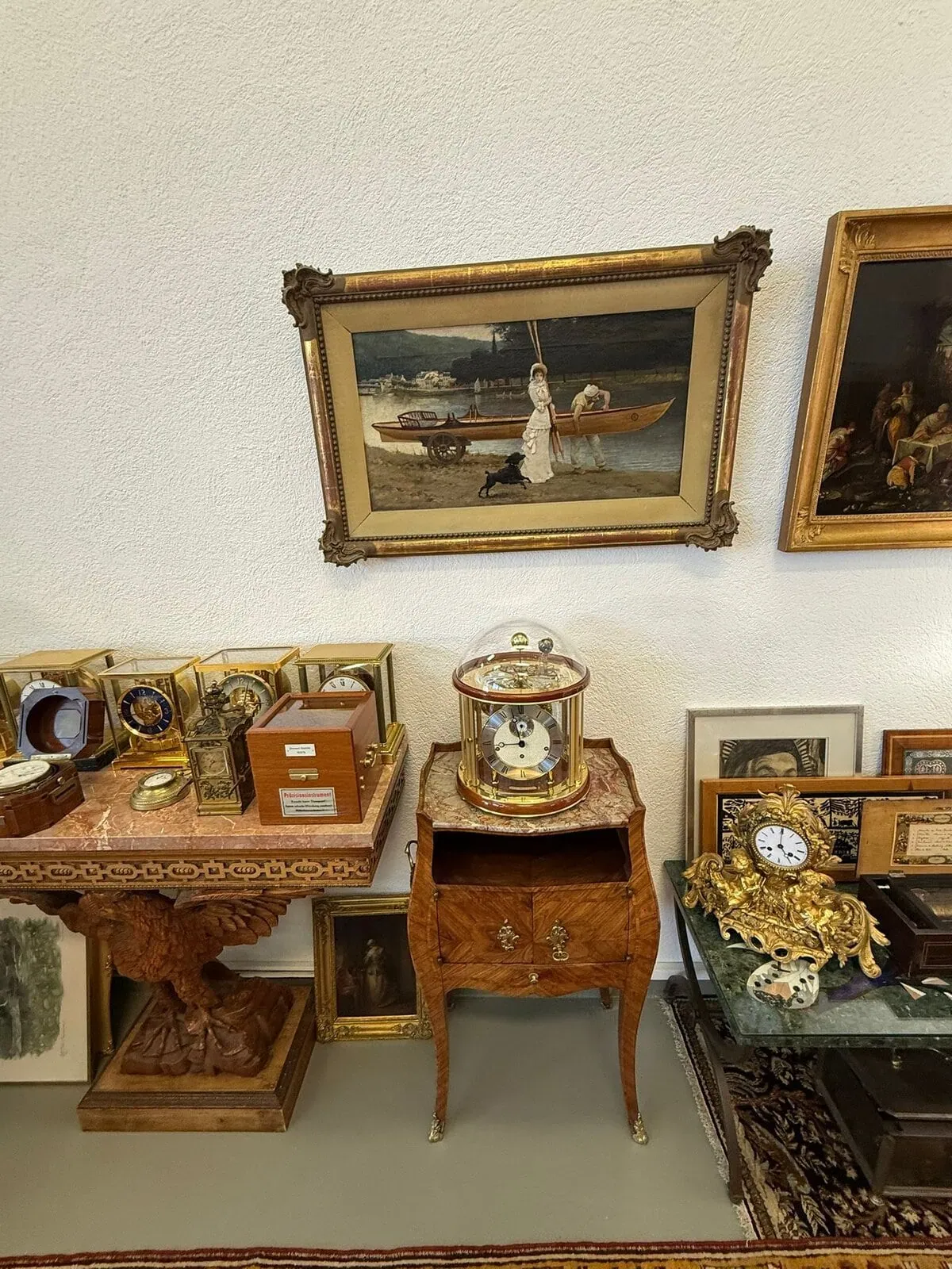 Salle avec tableaux et horloges anciennes sur des meubles.