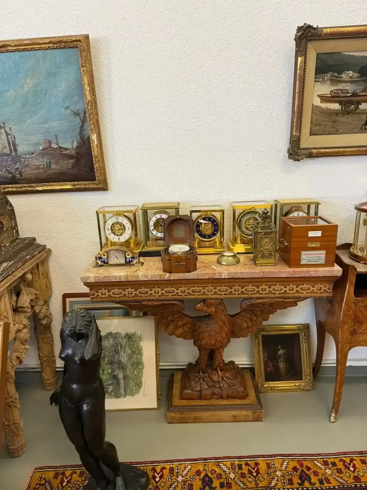 Anciennes horloges et sculptures exposées dans une galerie.