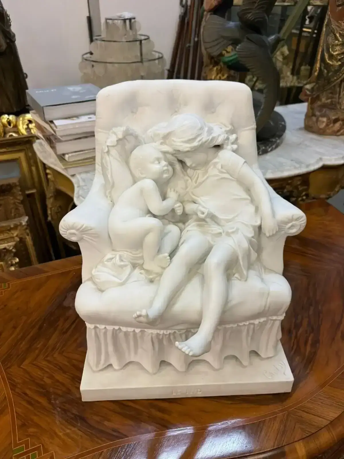 Sculpture d’enfants endormis sur un fauteuil en marbre.