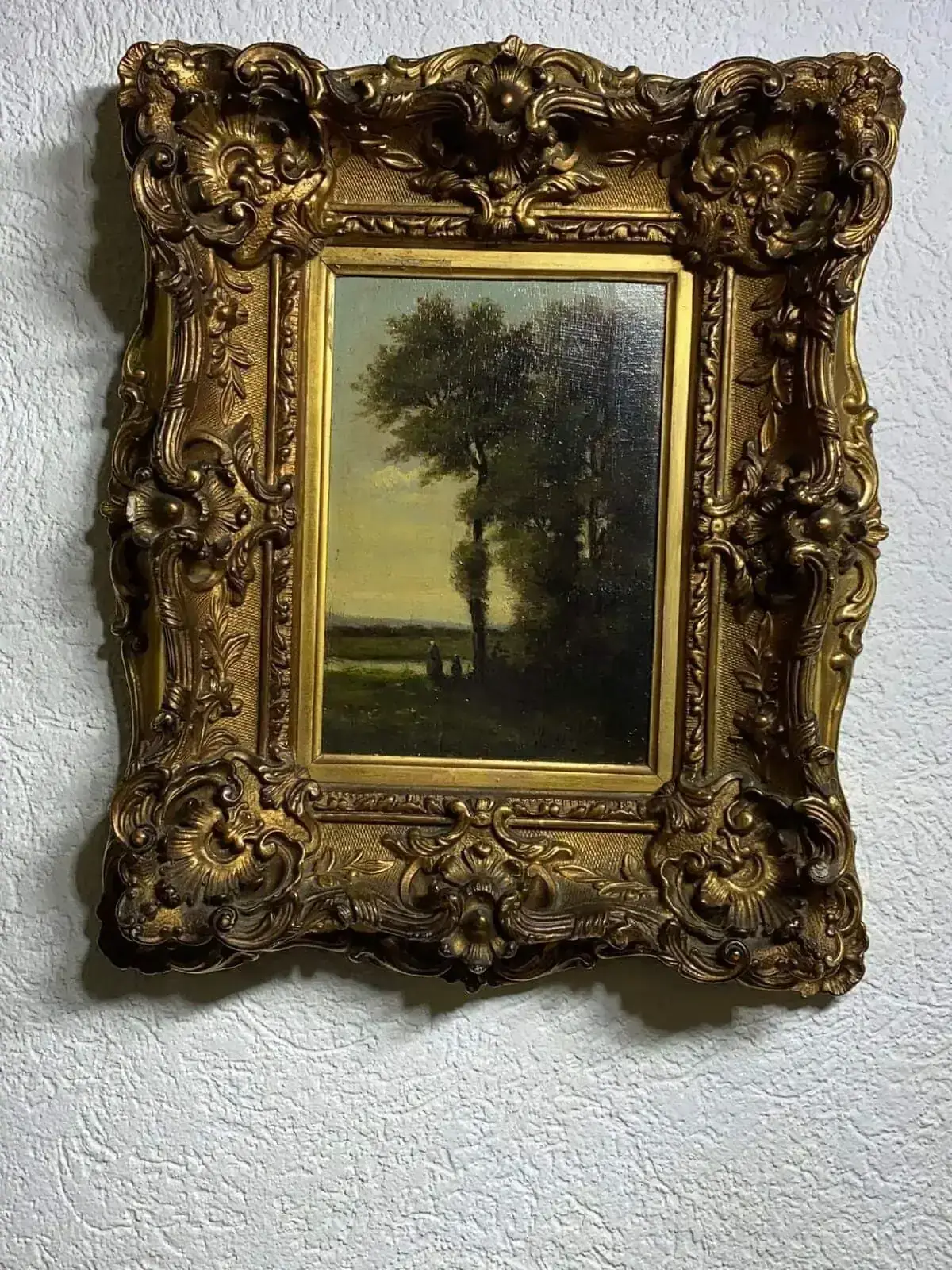 Peinture paysagère encadrée d’un cadre doré sculpté