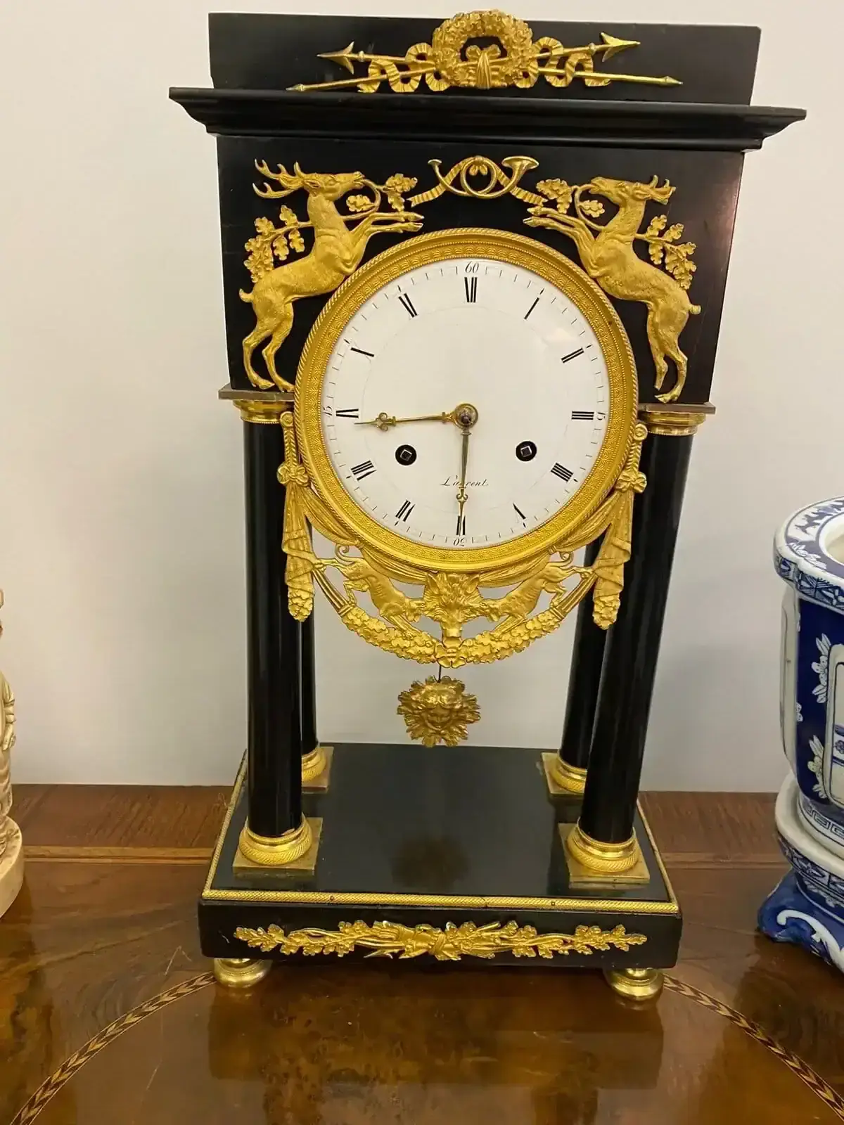 Pendule ancienne noire et dorée à motifs de cerfs