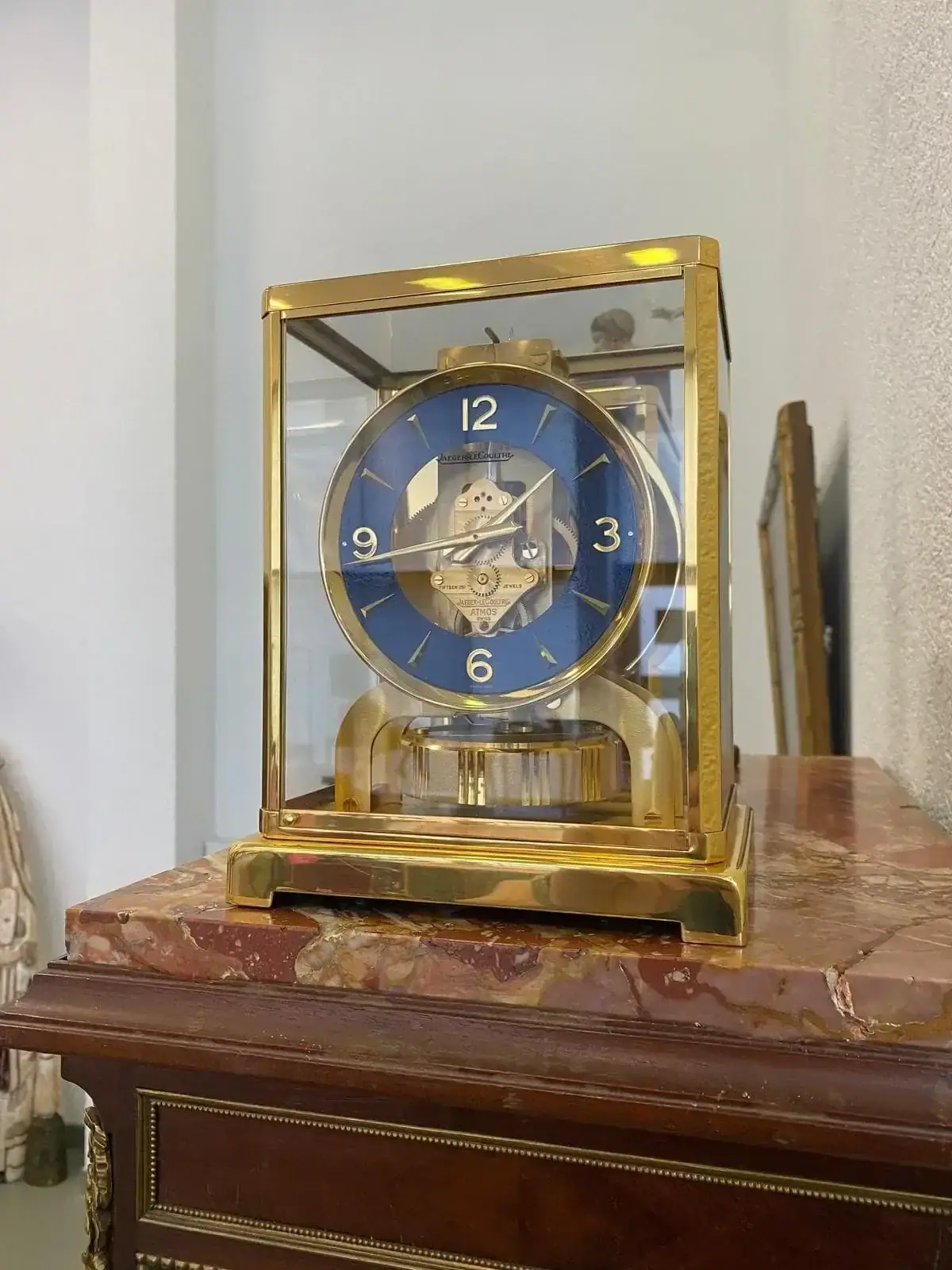 Horloge dorée à cadran bleu sur meuble ancien