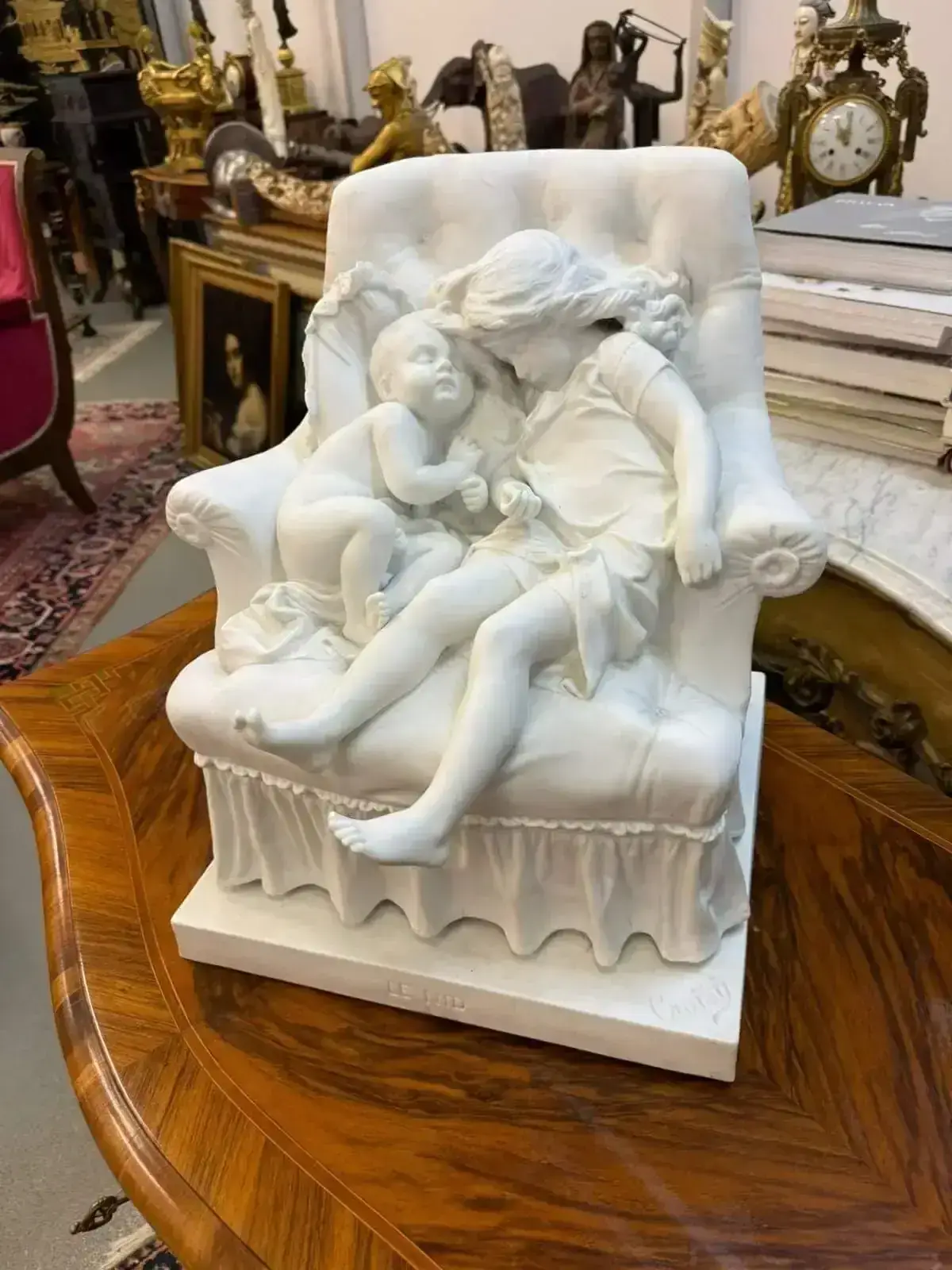 Sculpture d’enfants endormis sur un fauteuil en marbre.