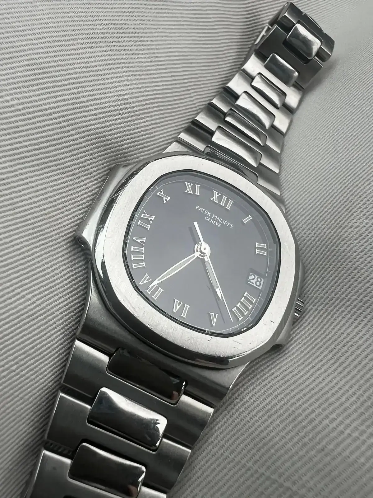 Montre en acier avec cadran noir et chiffres romains