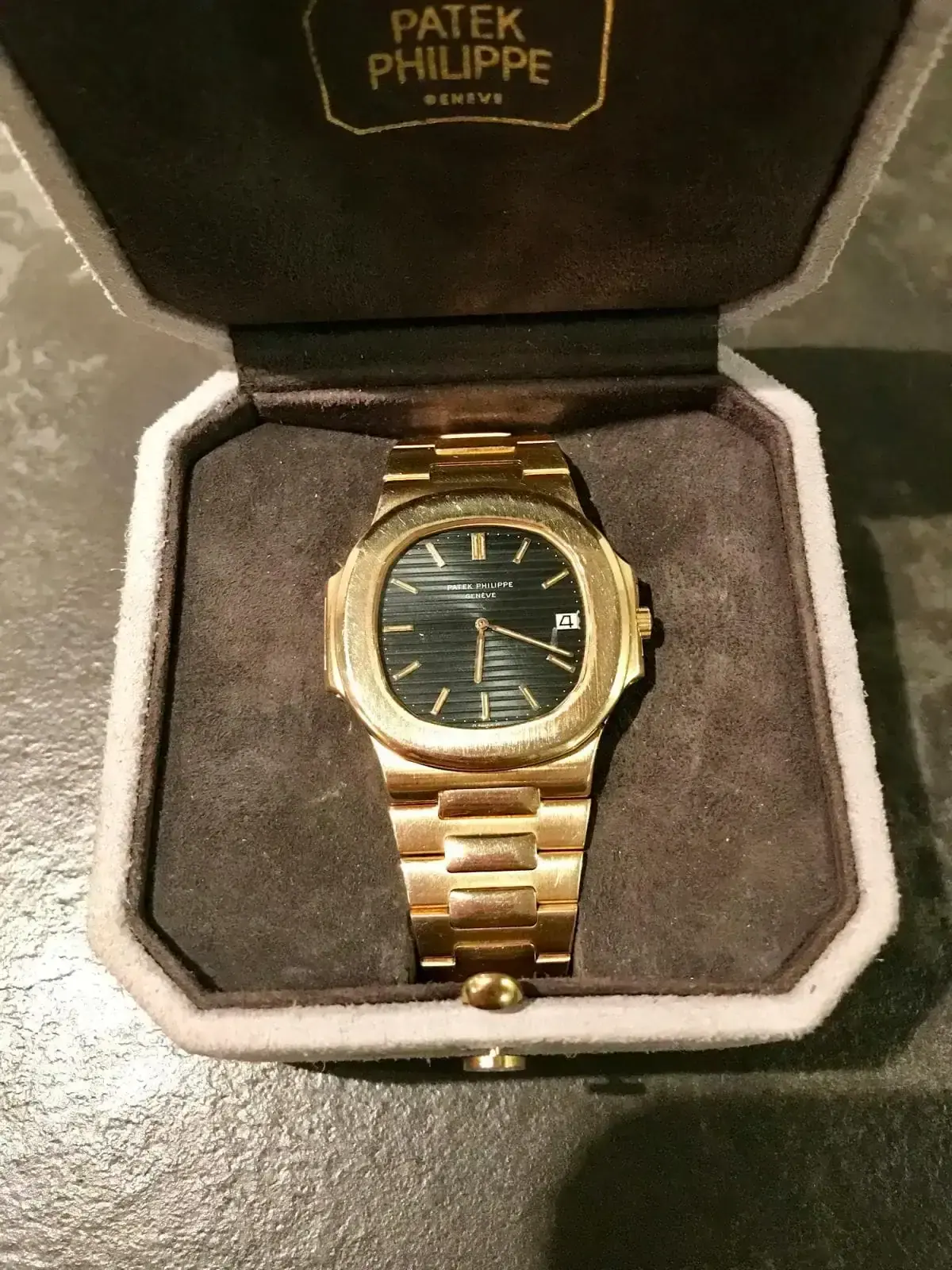 Montre dorée dans son écrin ouvert.