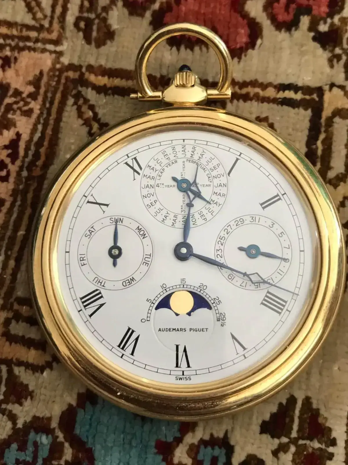 Montre de poche dorée à cadran complexe.