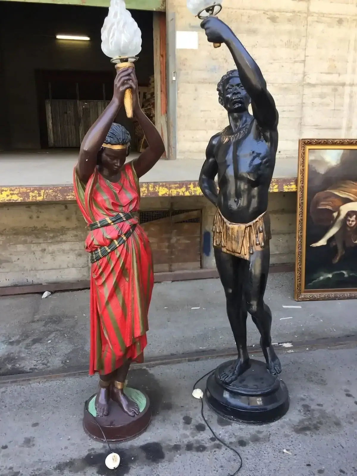 Deux statues tenant des torches décoratives.